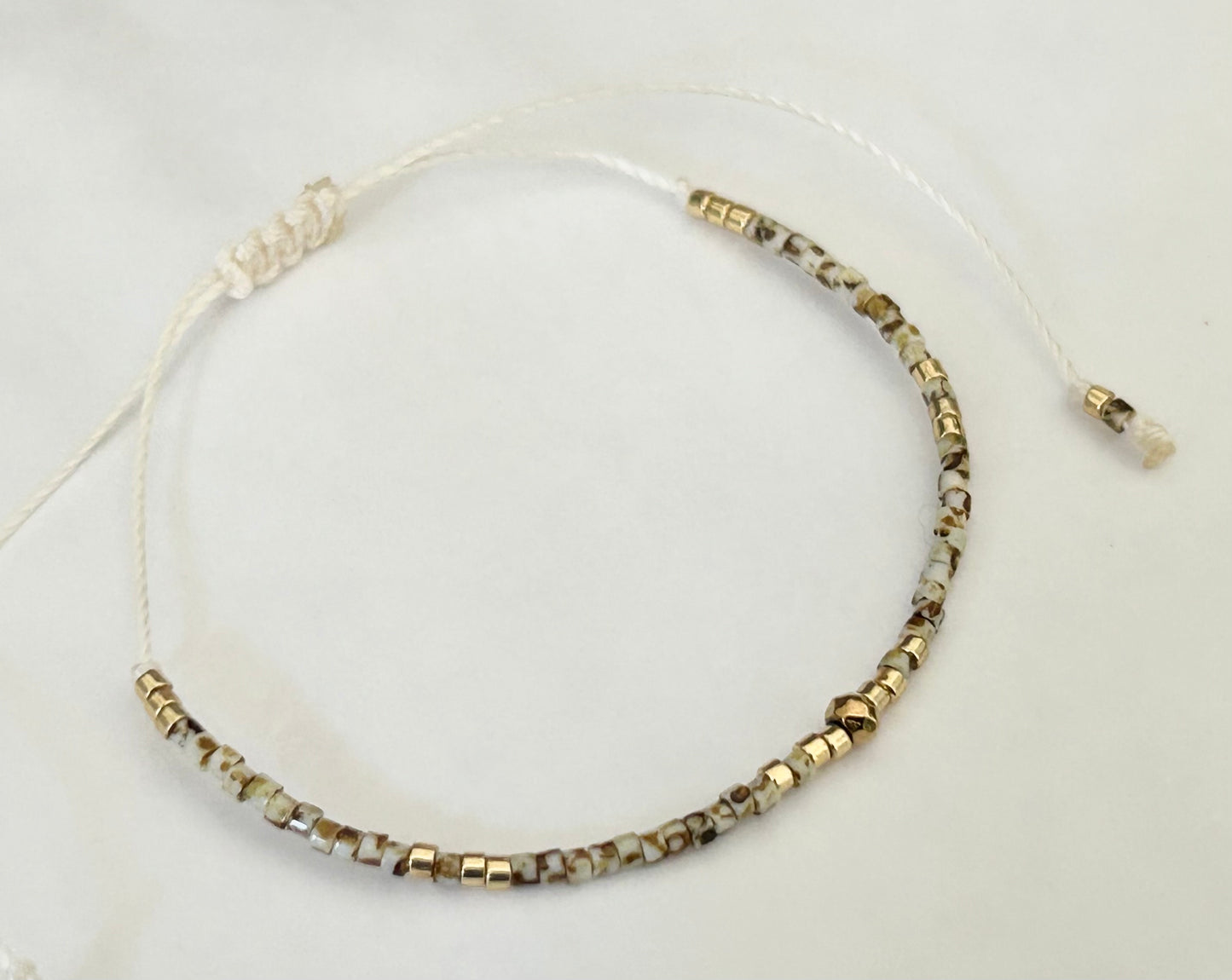 Bracelet cordon ajustable perles japonaises Miyuki Picasso beige et plaqué or 24 carats